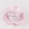 Candela da massaggio Vivalù Mandorla e Fiori d'Arancio in contenitore bianco con confezione rosa aperta, vista dall'alto.