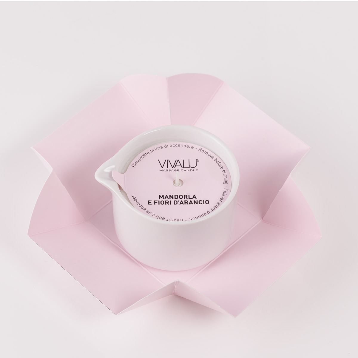 Candela da massaggio Vivalù Mandorla e Fiori d'Arancio in contenitore bianco con confezione rosa aperta, vista dall'alto.