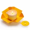 Candela da massaggio al miele Vivalu accesa, con confezione aperta e tappo rimosso.