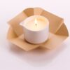 Candela da massaggio all'argan Vivalu accesa, con confezione aperta color oro e fiamma ardente.