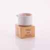 Candela da massaggio all'argan Vivalu posizionata sulla scatola color oro, con proprietà rassodanti e profumo naturale.