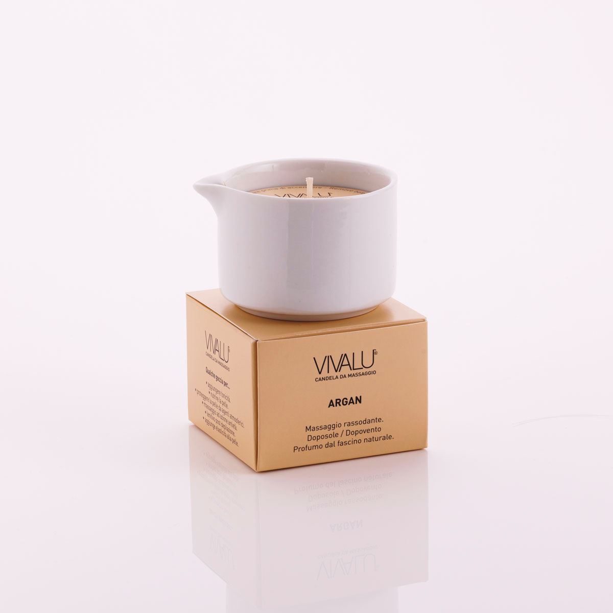 Candela da massaggio all'argan Vivalu posizionata sulla scatola color oro, con proprietà rassodanti e profumo naturale.