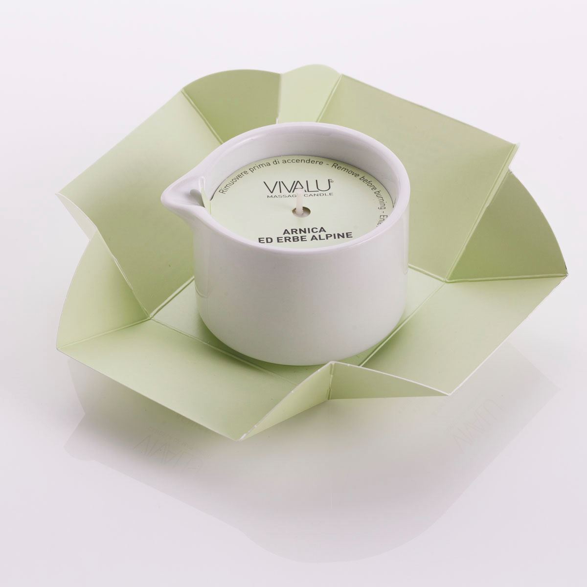 Candela da massaggio all'arnica ed erbe alpine Vivalu in confezione aperta, con protezione in cartone verde.