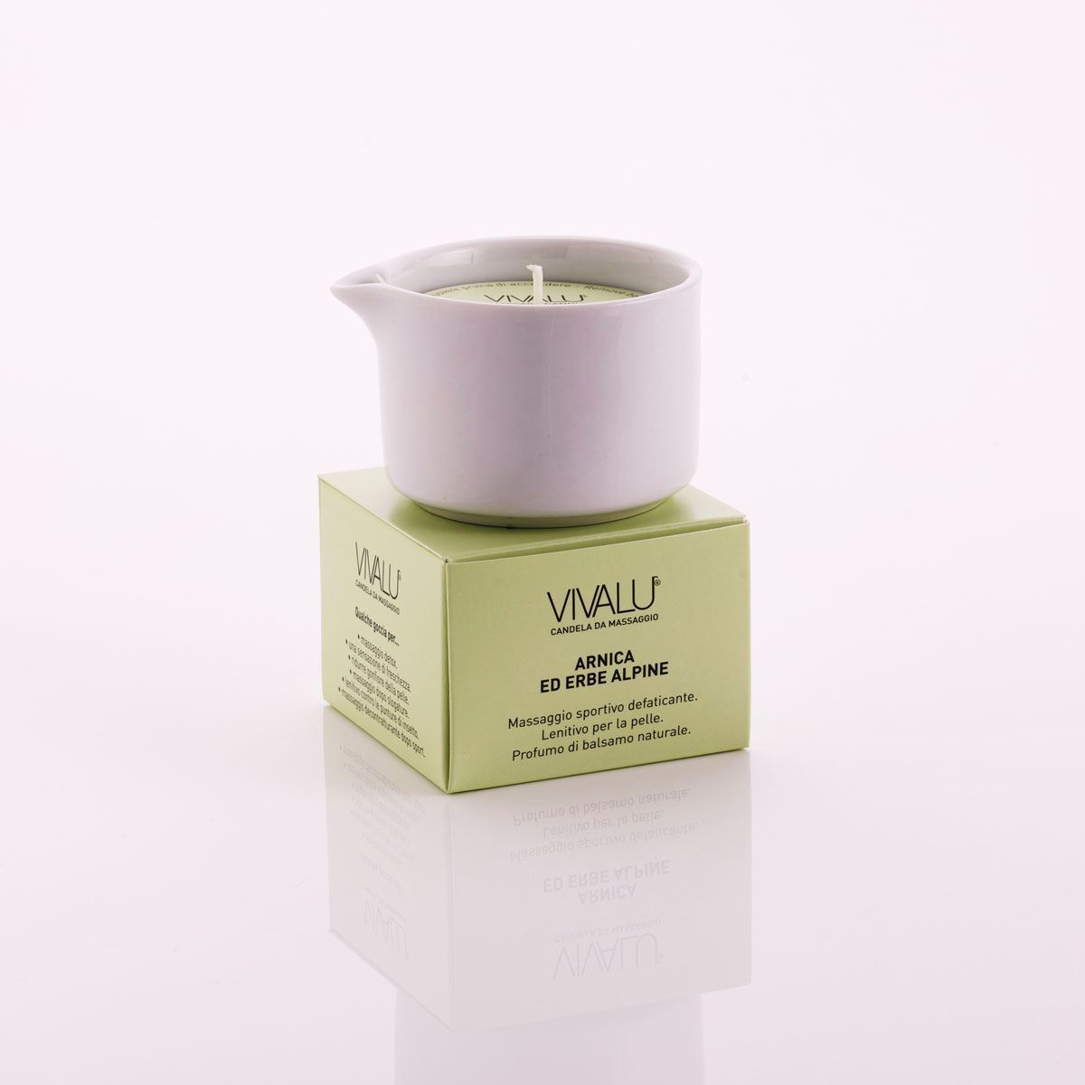 Candela da massaggio all'arnica ed erbe alpine Vivalu in contenitore bianco su scatola verde, con proprietà defaticanti e lenitive.