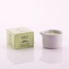 Candela da massaggio all'arnica ed erbe alpine Vivalu in contenitore bianco con scatola verde accanto.
