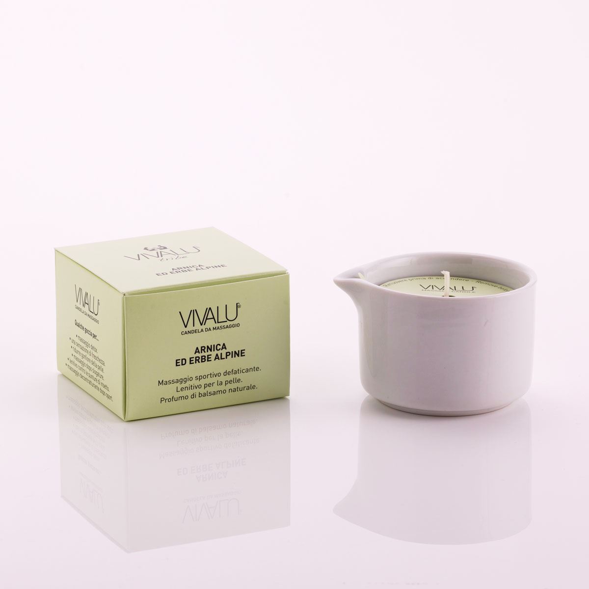 Candela da massaggio all'arnica ed erbe alpine Vivalu in contenitore bianco con scatola verde accanto.