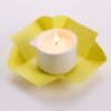 Candela da massaggio ai vinaccioli d'uva Vivalu accesa, con confezione aperta gialla e fiamma ardente.