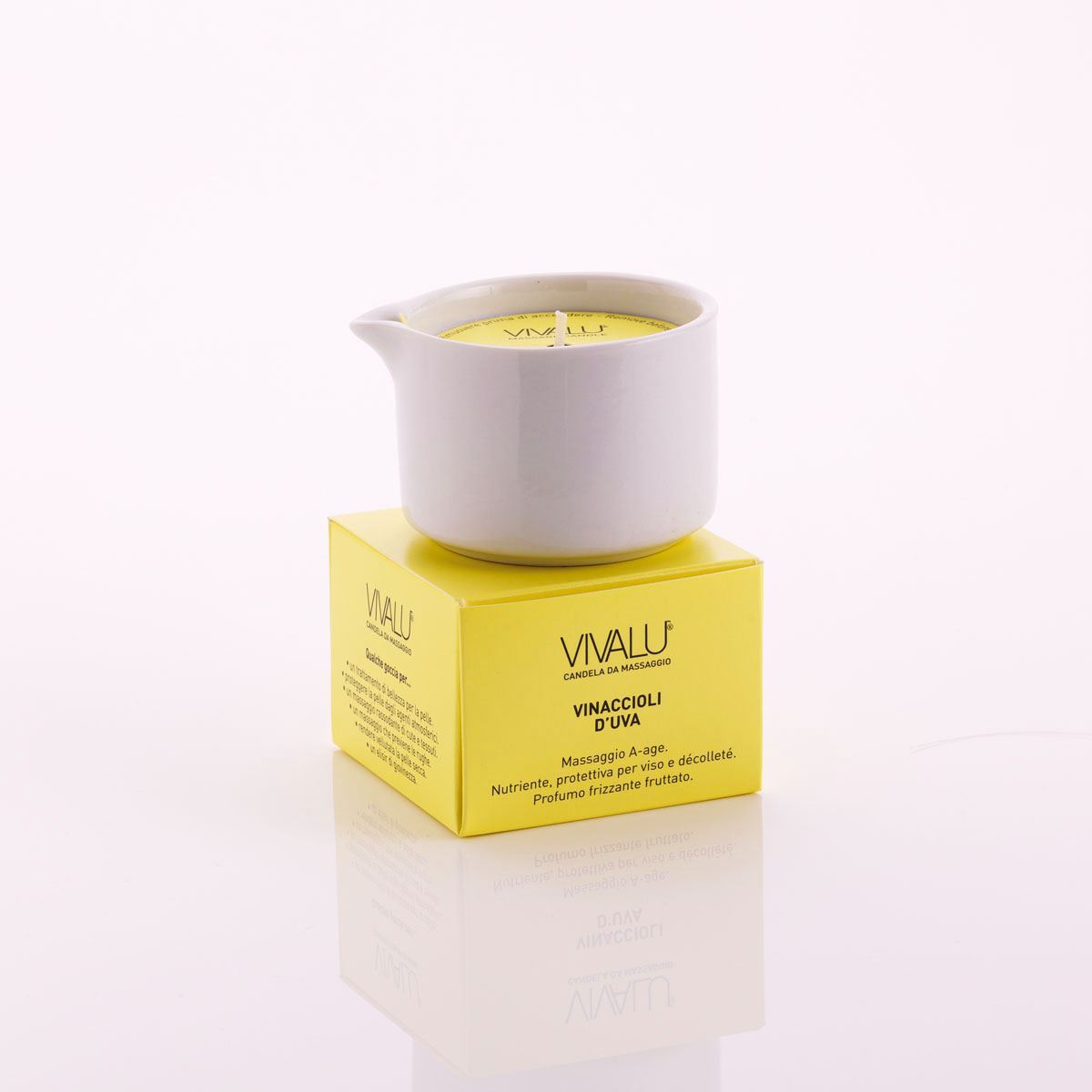 Candela da massaggio ai vinaccioli d'uva Vivalu posizionata sulla scatola color giallo, con proprietà anti-age e profumo fruttato.
