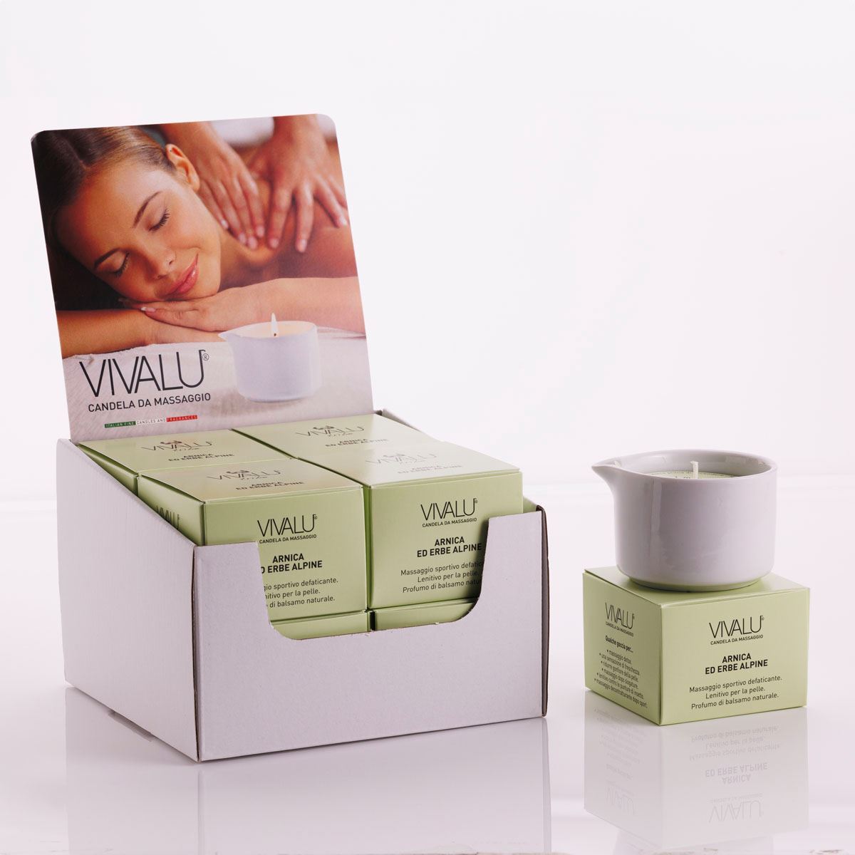 Espositore con candele da massaggio all'arnica ed erbe alpine Vivalu, con scatole verdi e immagine promozionale.
