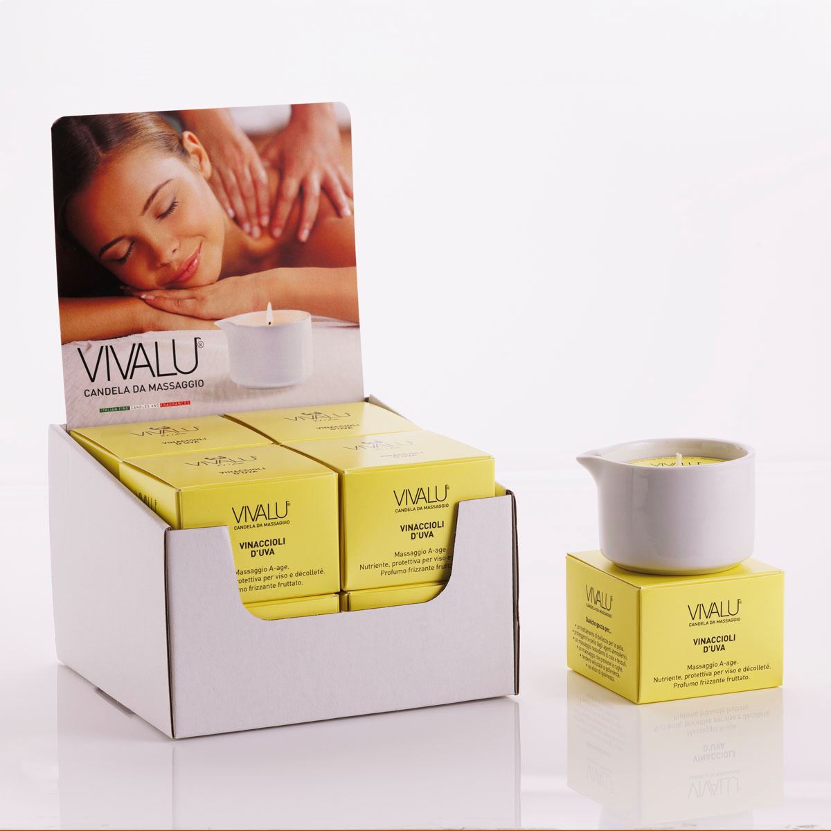 Espositore con candele da massaggio ai vinaccioli d'uva Vivalu, con scatole gialle e immagine promozionale.